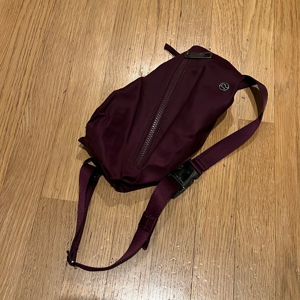 Lululemon belt bag unique burgundy color with diagonal zip in front for sunglass